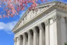 Washington D.C. US Supreme Court building. during spring time; cherry blossoms seen in front of image of Supreme Court
