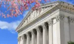 Washington D.C. US Supreme Court building. during spring time; cherry blossoms seen in front of image of Supreme Court