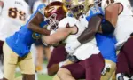 Arizona State running back Cam Skattebo #4 runs against UCLA defensive line Gary Smith III #58 and defensive back Alex Johnson #36 during an NCAA college football game^ Nov. 11^ 2023^ in Pasadena.