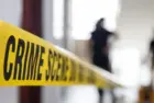 crime scene tape in building with blurred forensic team background