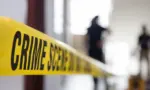 crime scene tape in building with blurred forensic team background