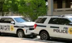 Police patrol cars used by the FBI parked on a street outside the J Edgar Hoover headquarters building in downtown Washington DC. Washington DC^ USA - 30 April 2024