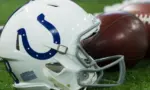 Indianapolis Colts helmet shown on field next to football; Colts host the Oakland Raiders on 9/29/19 at Lucas Oil Stadium in Indianapolis IN-USA