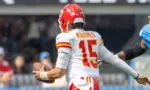 KC Chiefs quarterback Patrick Mahomes #15 runs to escape a tackle by LA Chargers outside linebacker Bud Dupree #48 during an NFL football game at SoFi Stadium^ Aug. 17^ 2024^ in Inglewood^ Calif.
