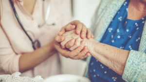 senior-woman-and-nurse-holding-hands