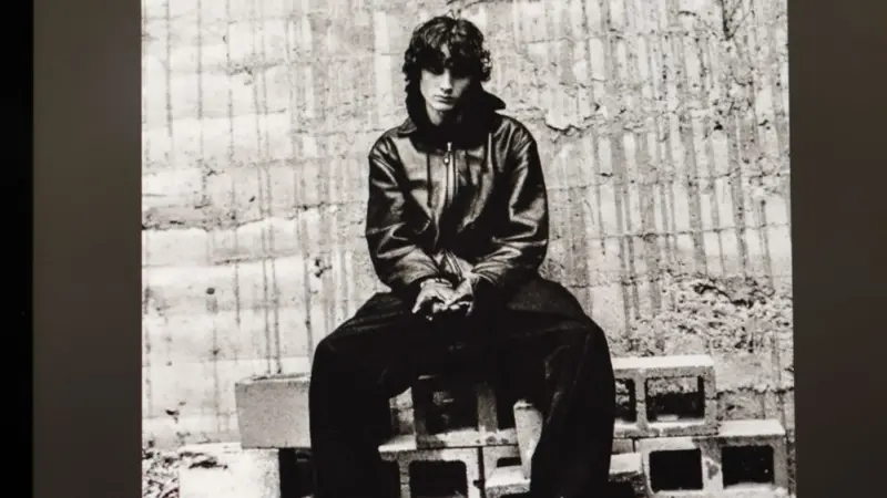 An Apple iPad displays the Spotify music streaming app. The screen the shows the song 