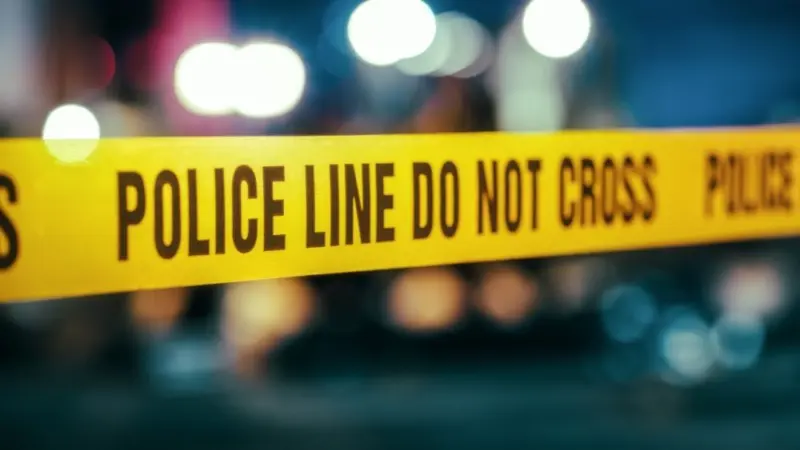 Yellow Tape Showing Text "Police Line Do Not Cross" Restricting a Crime Scene Area At Night. Close Up Aesthetic Shot with Bokeh Effect and Flickering Lights. Criminal on the Loose Strikes Again