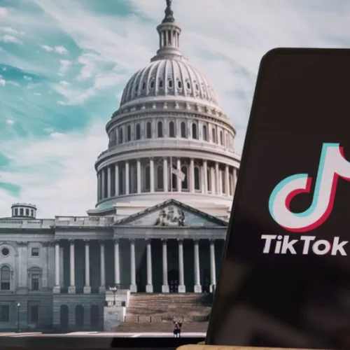 TikTok sign in the foreground^ while American Congress building is blurred in the background^ concept for TikTok ban in the United States