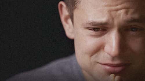close-up-of-crying-young-white-man-looking-down-horizontal-2
