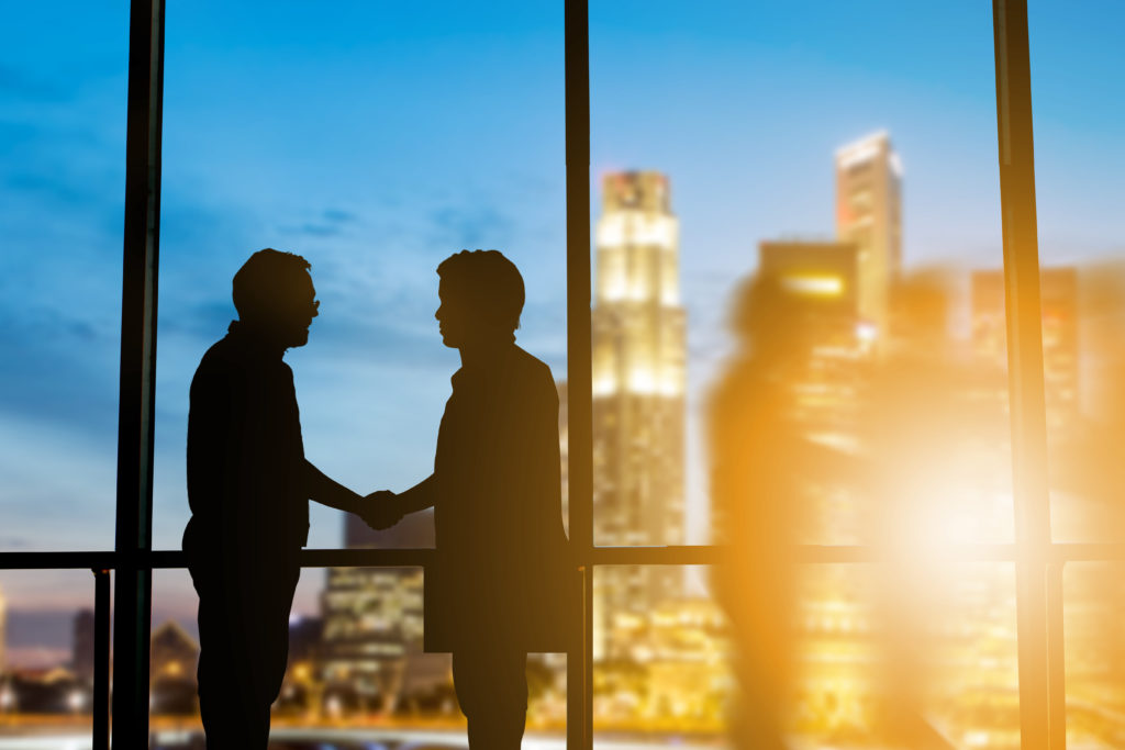 silhouettebusinessmenshakehandsfinishingadealbetweenbusinessessuccess