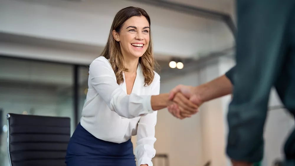happymidagedbusinesswomanmanagerhandshakinggreetingclientin