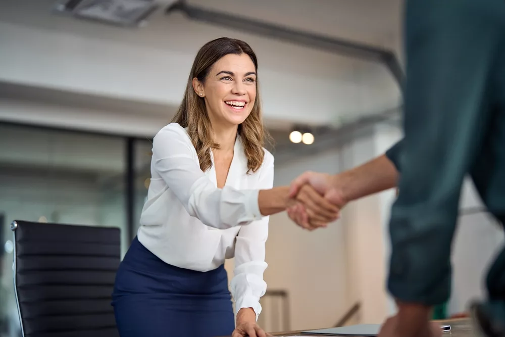 happymidagedbusinesswomanmanagerhandshakinggreetingclientin
