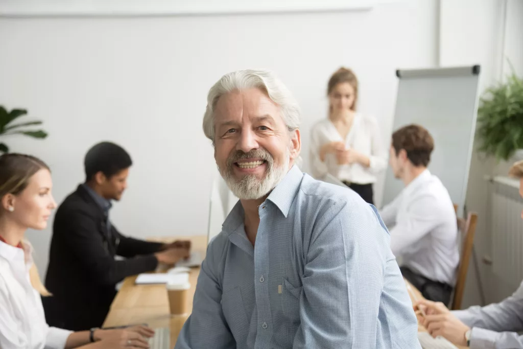 smilingmaleseniorteamleaderagedteacherlookingatcamera