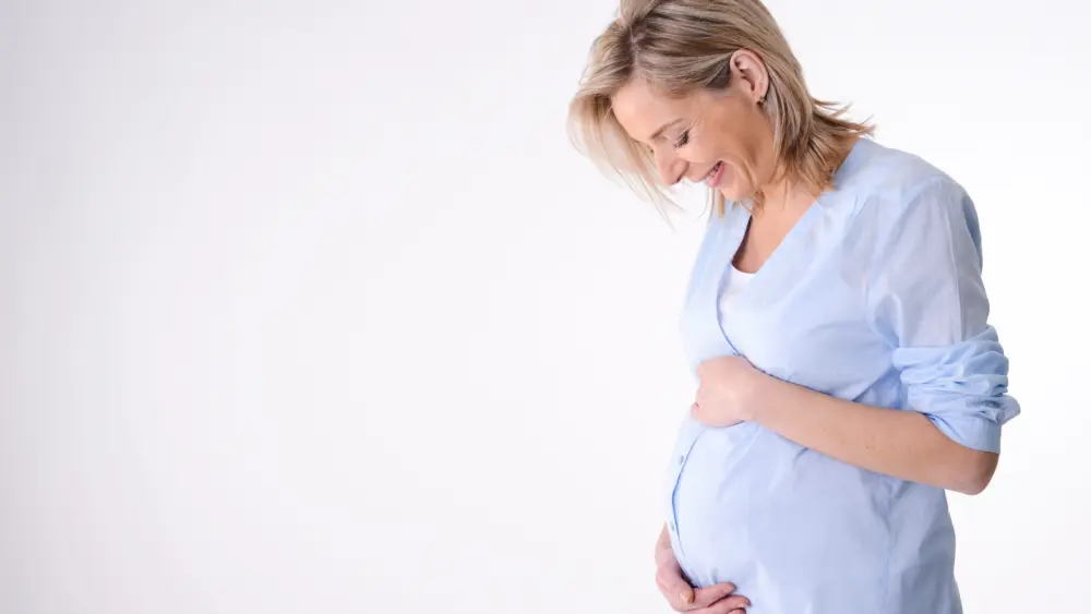 cheerfulmaturefortyyearsoldpregnantwomanisolatedona