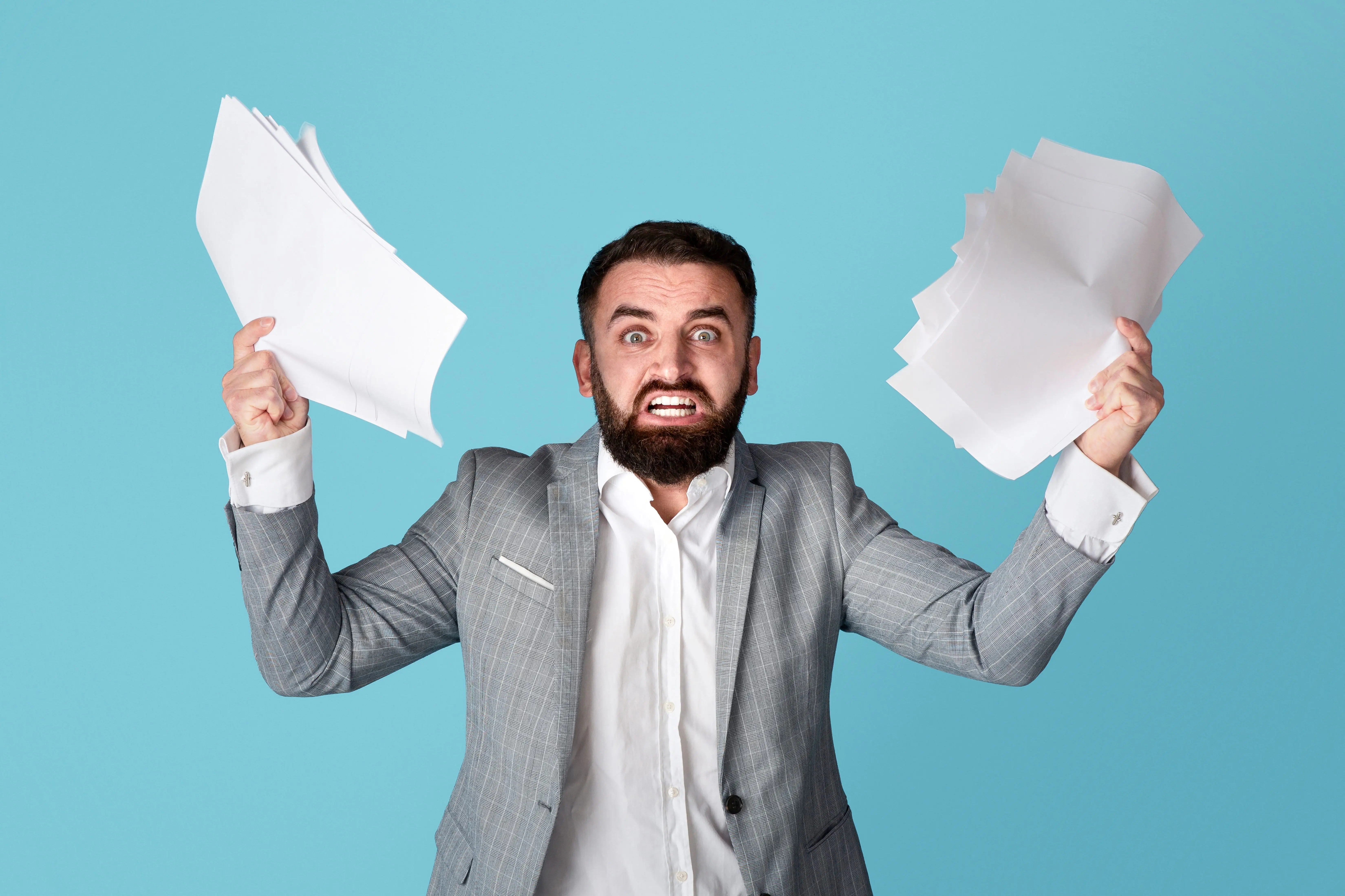 dealingwithworkplacestress-angryoverworkedofficeemployeegraspingpaper