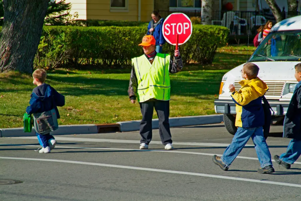 elementaryschoolcrossingguardprovidessafetytochildrencrossingbusy