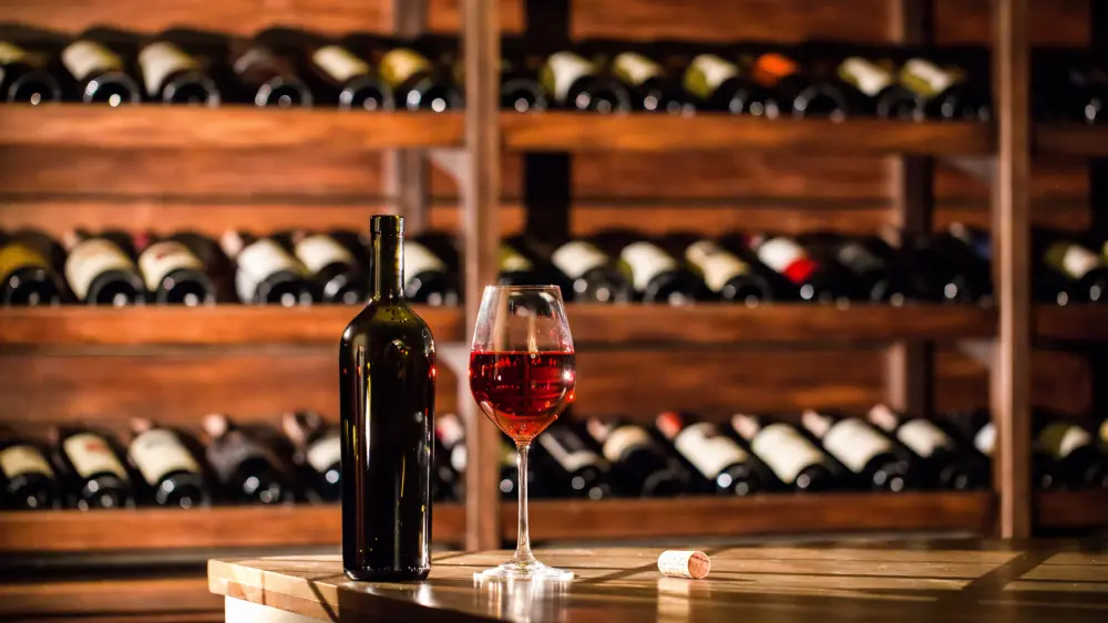 bottleandglassfilledwithredwineplacedona