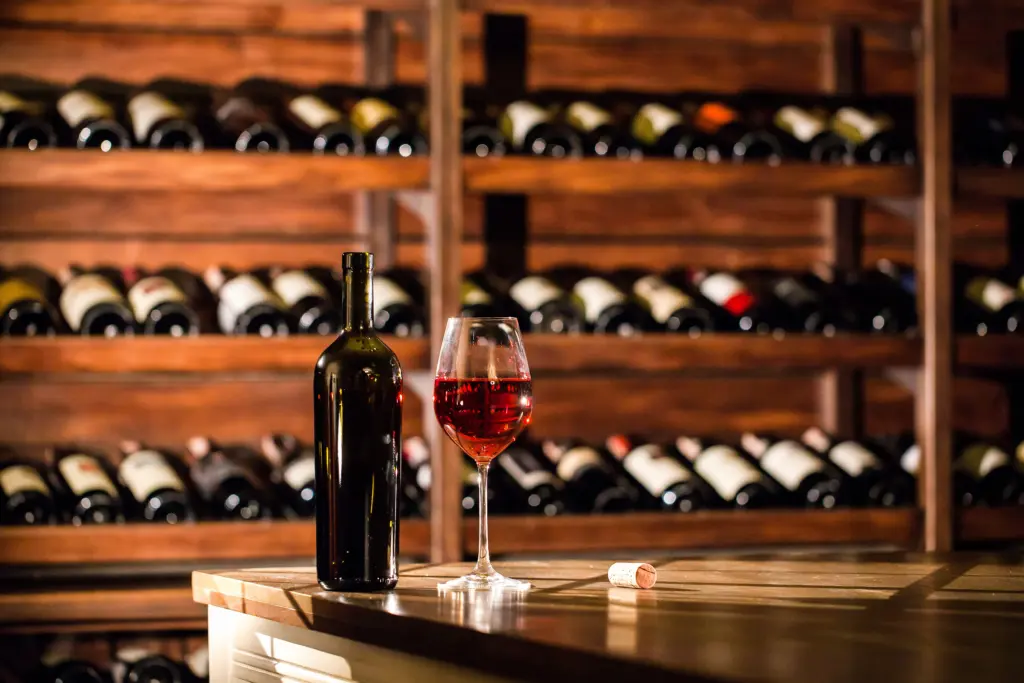 bottleandglassfilledwithredwineplacedona