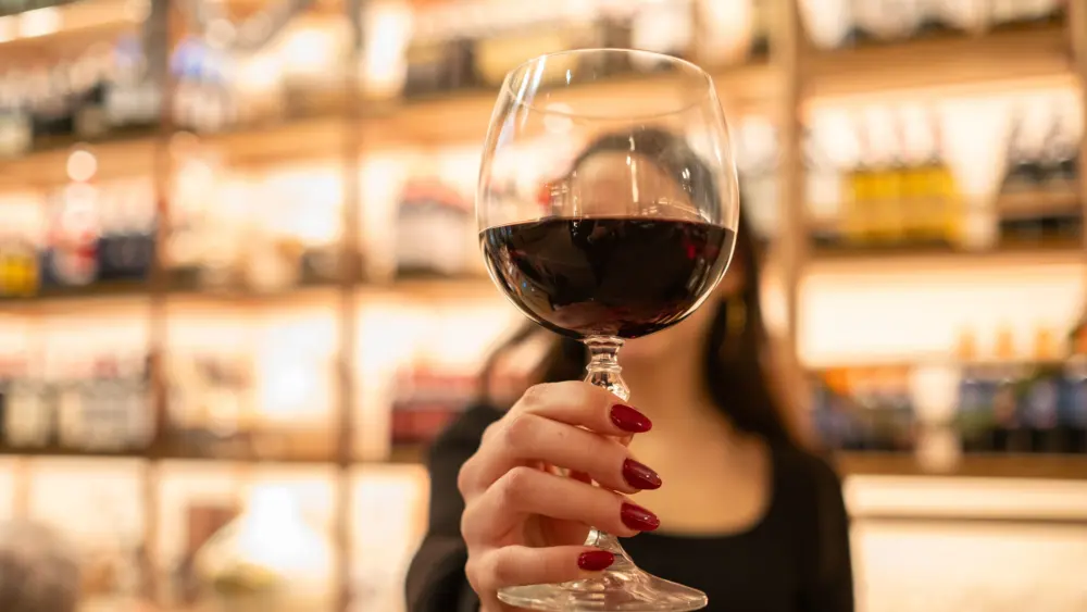 ayoungwomanholdsafinecrystalglassofwine