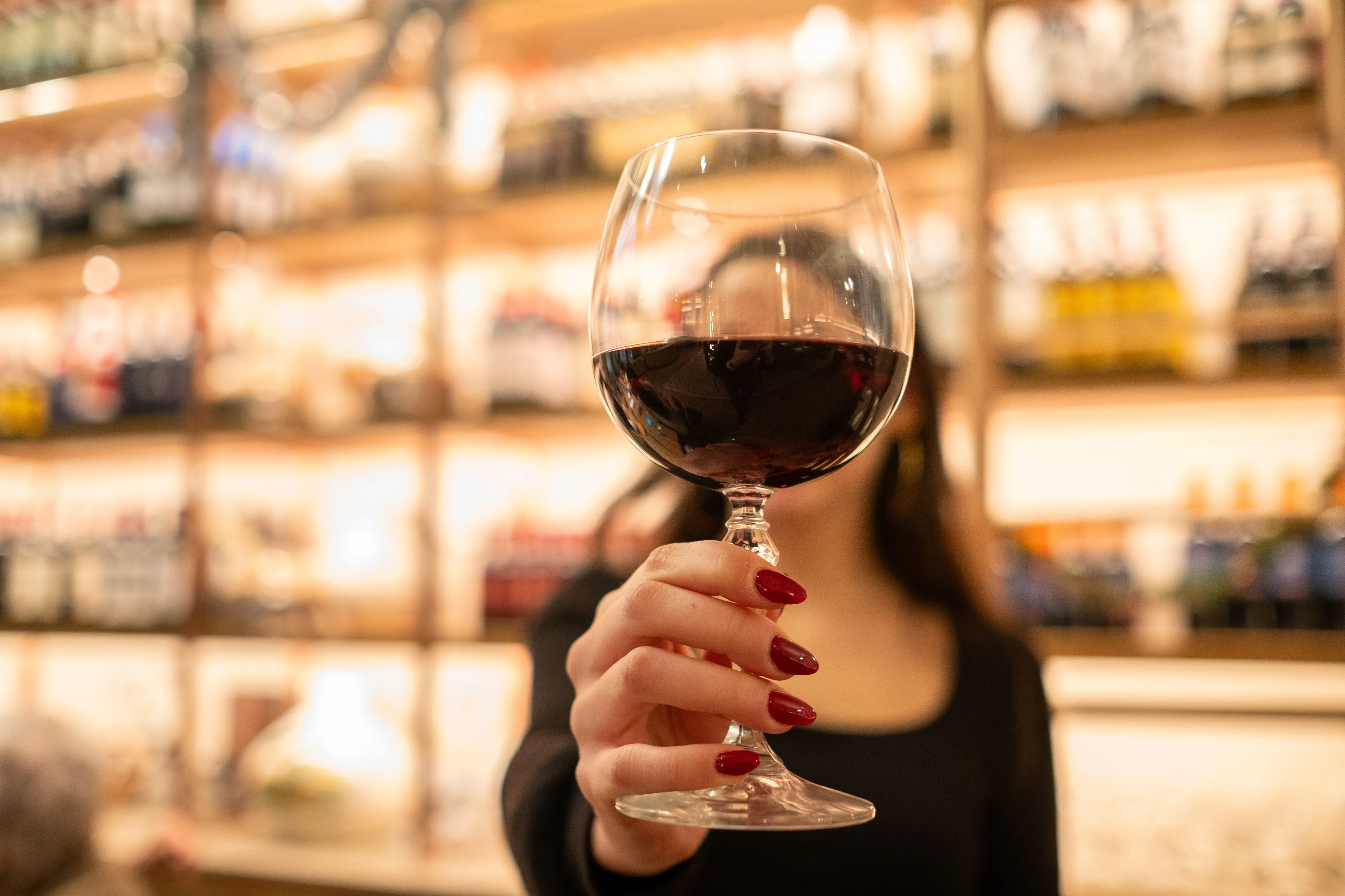 ayoungwomanholdsafinecrystalglassofwine