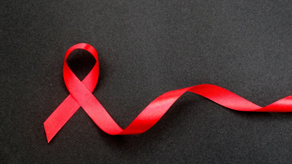 aidredribboninhandonablackbackgrounda