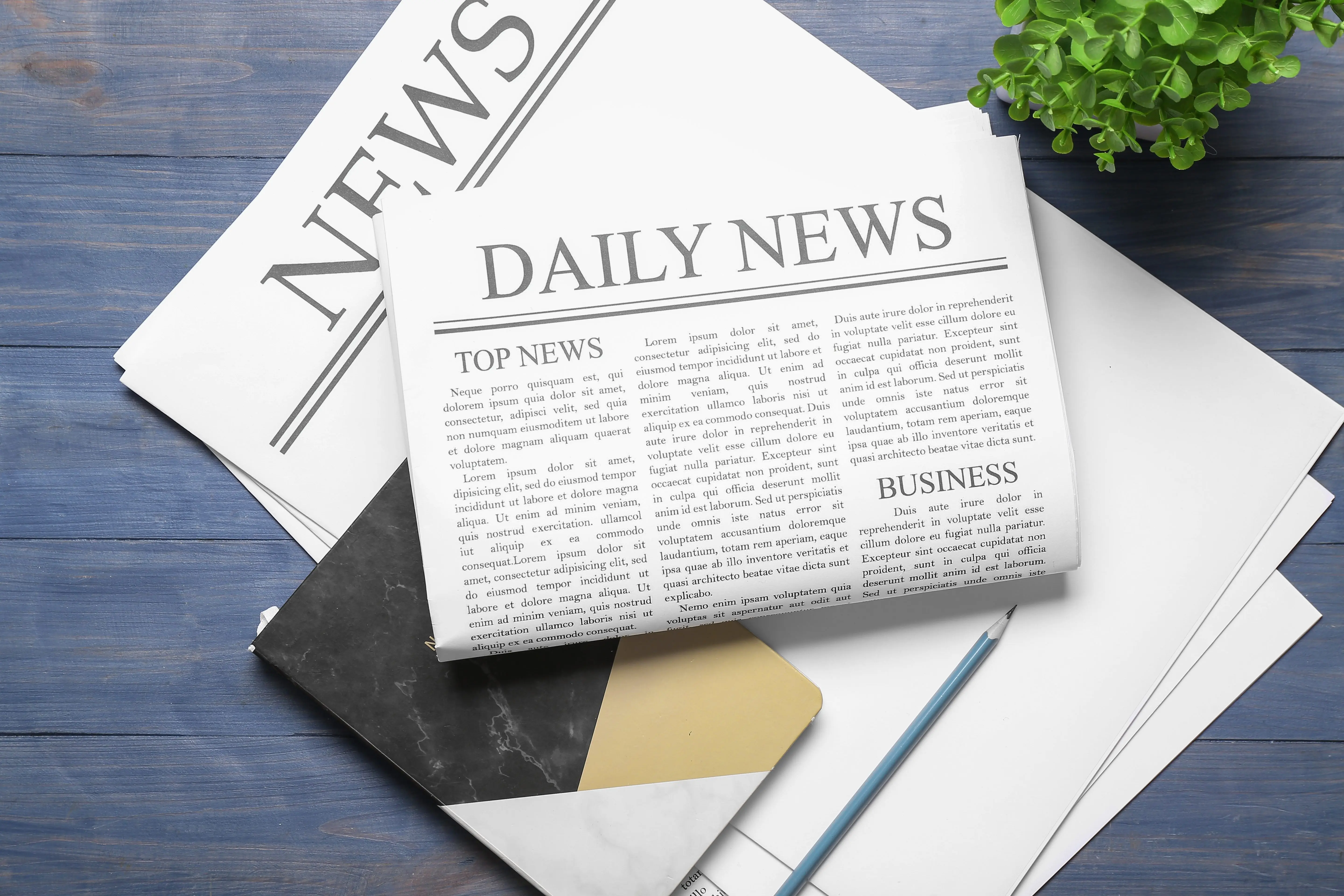 newspaperswithnotebookandpencilonbluewoodenbackground