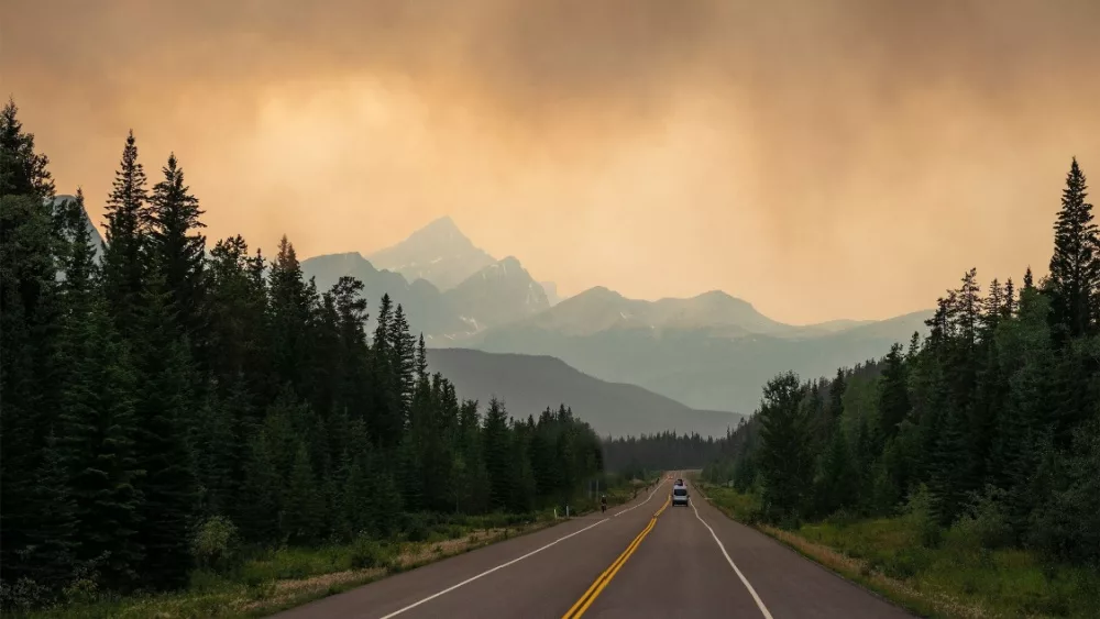 Dramatic landscape with smoke clouds along a highway in British Columbia during wildfires^ Canada.