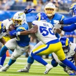 LA Chargers running back Kimani Vidal #30 runs the ball fighting off pressure from the LA Rams in an NFL football game at SoFi Stadium^ Aug. 17^ 2024^ in Inglewood^ CA.