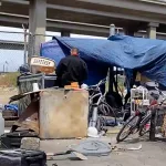 a-person-standing-in-front-of-a-homeless-encampment-under-i-880-in-oakland-california-on-may-26-2022-cynthia-caintd-television655407