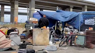 a-person-standing-in-front-of-a-homeless-encampment-under-i-880-in-oakland-california-on-may-26-2022-cynthia-caintd-television655407