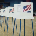 Voting booths with American flag logo at polling station. National Election Day in the United States of America.