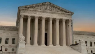 Greek classical architecture of the United States Supreme Court building with sunrise in background.