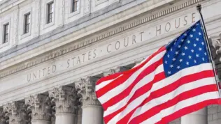 American flag waving in the wind in front of United States Court House in New York