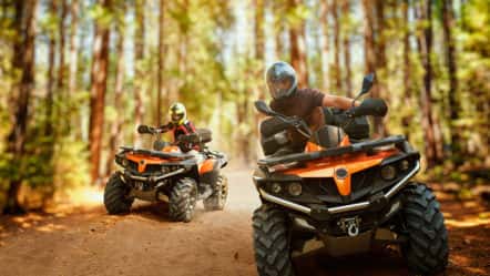 two-atv-riders-speed-race-in-forest-front-view