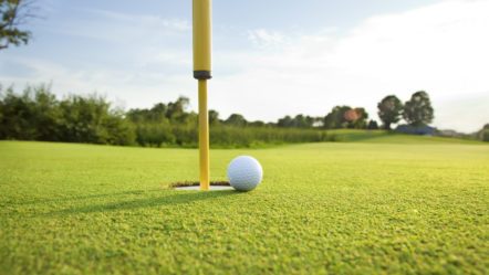 close-up-of-golf-ball-on-the-green-near-the-hole-on-a-sunny-afte