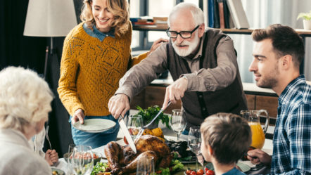 grandfather-cutting-turkey-for-family-on-thanksgiving-dinner