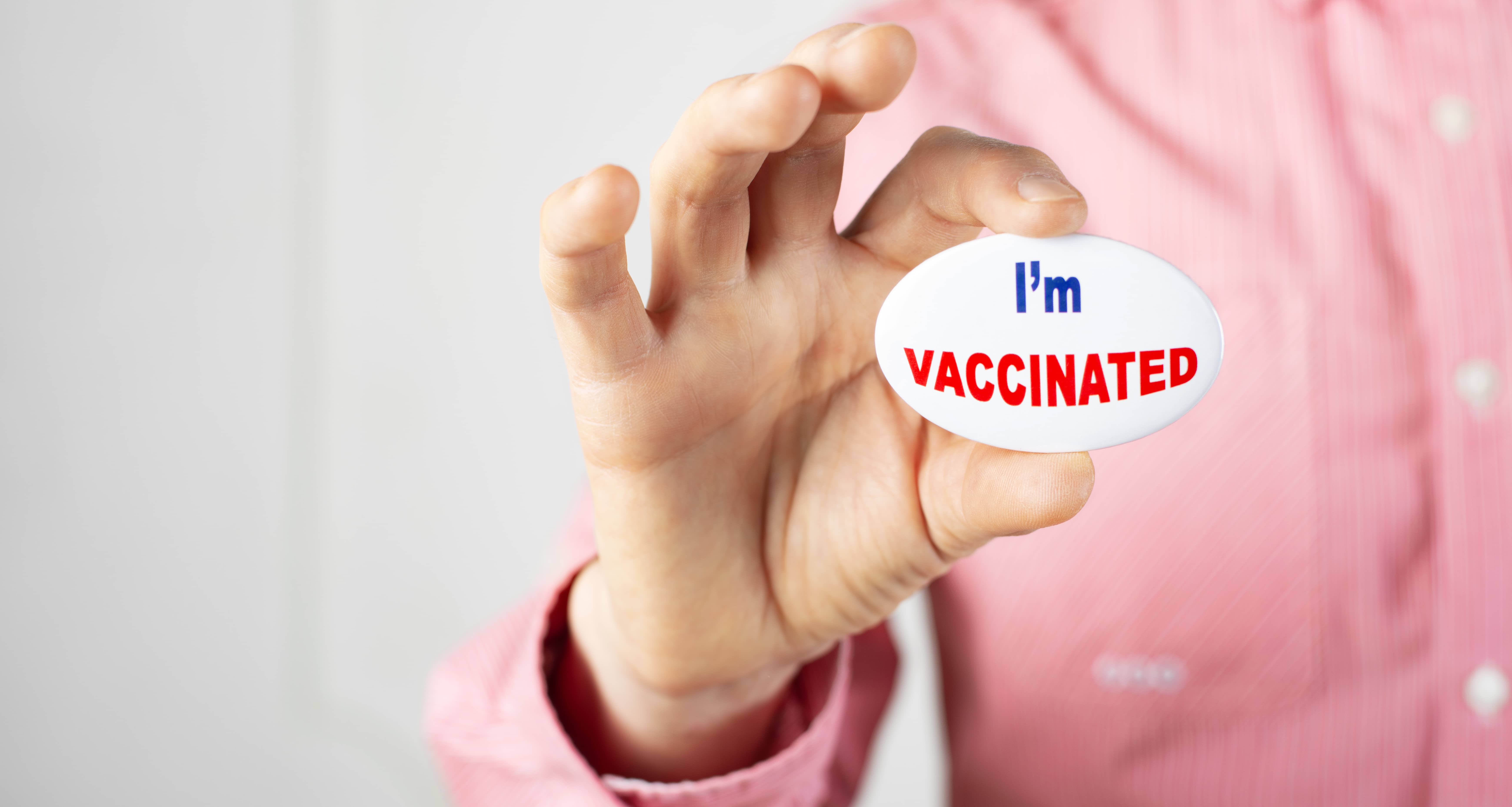 vaccination-campaign-button-pin-in-caucasian-male-fingers-copy