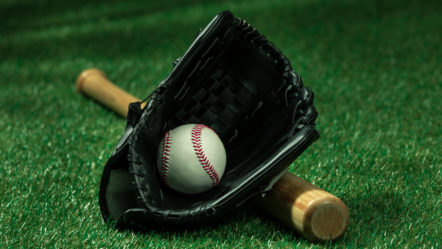 closeup-view-of-baseball-bat-glove-and-ball-lying-on-green-field