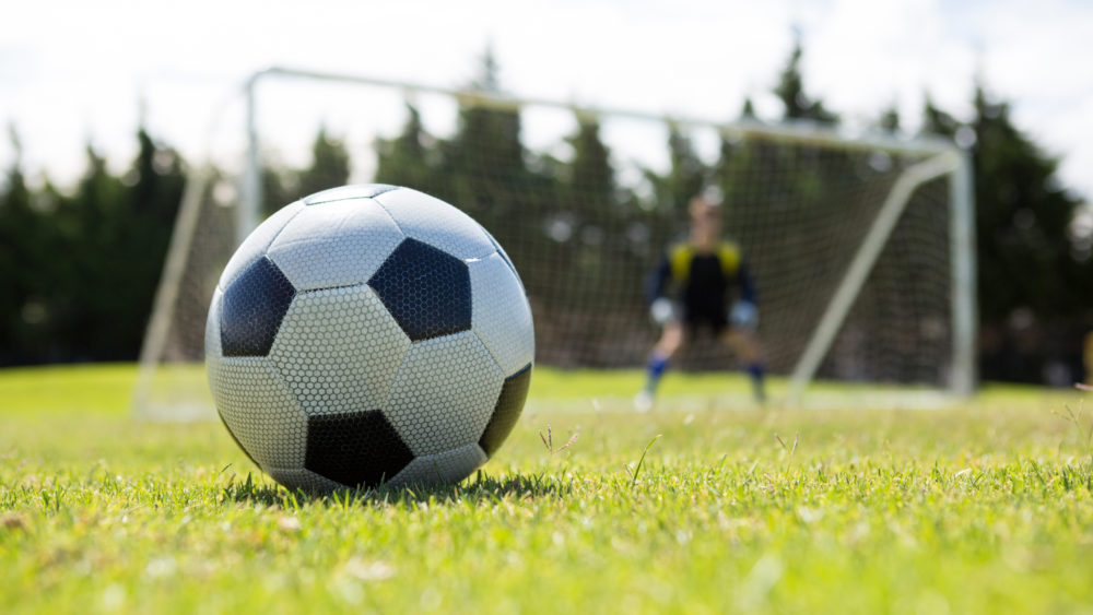close-up-of-soccer-ball-on-field-against-goalkeeper