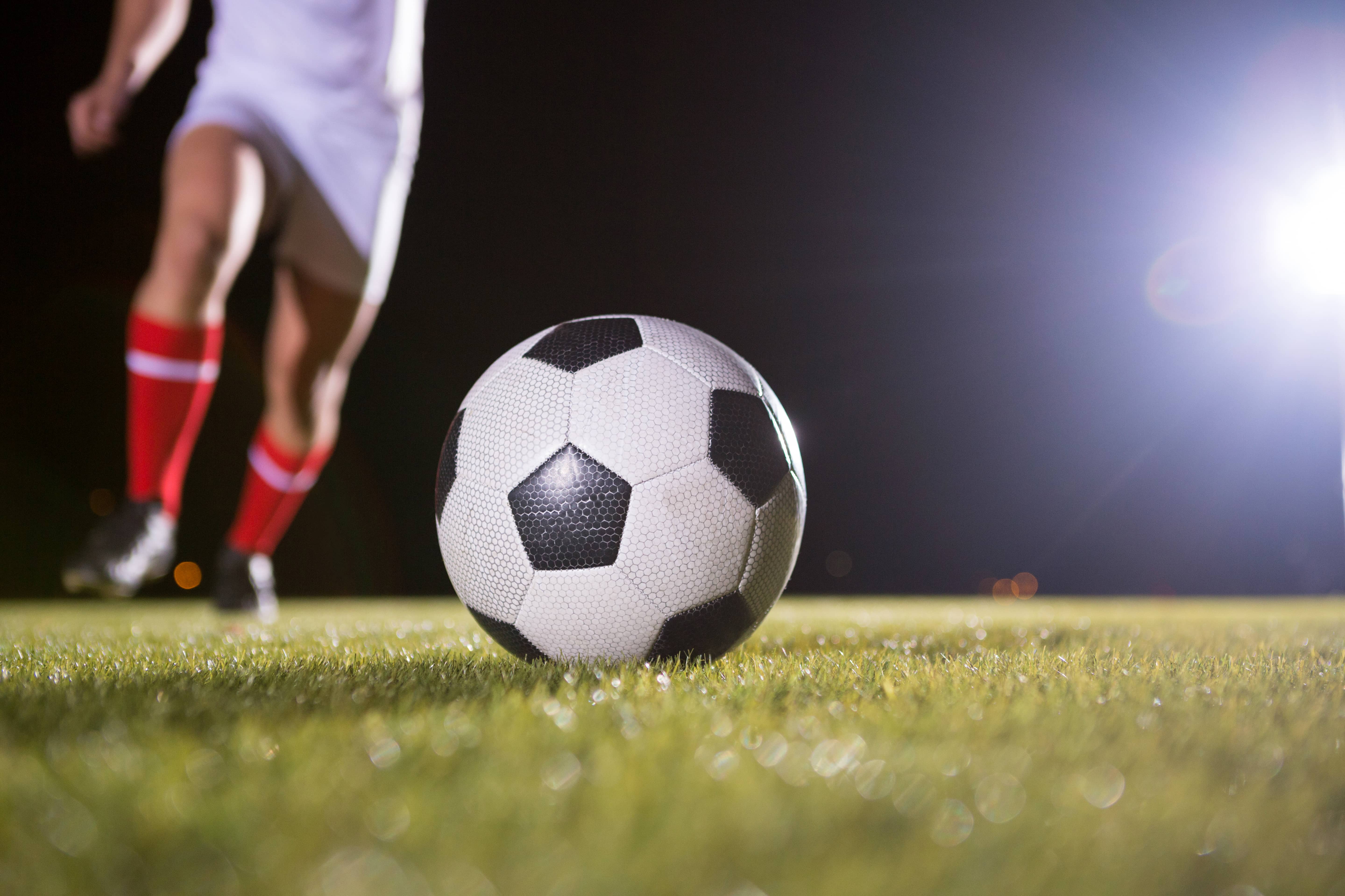 low-section-of-soccer-player-and-ball-on-field