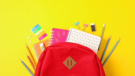 flat-lay-composition-with-backpack-and-school-supplies-on-color