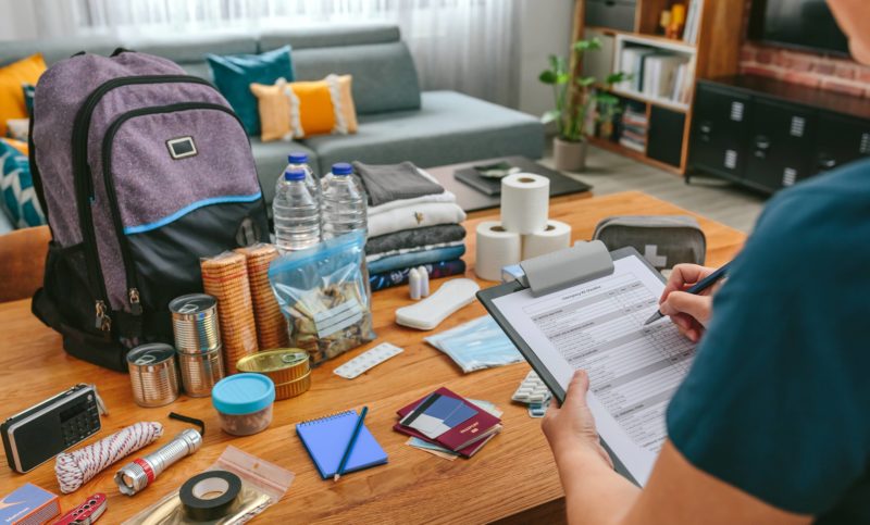woman-doing-checklist-of-emergency-backpack