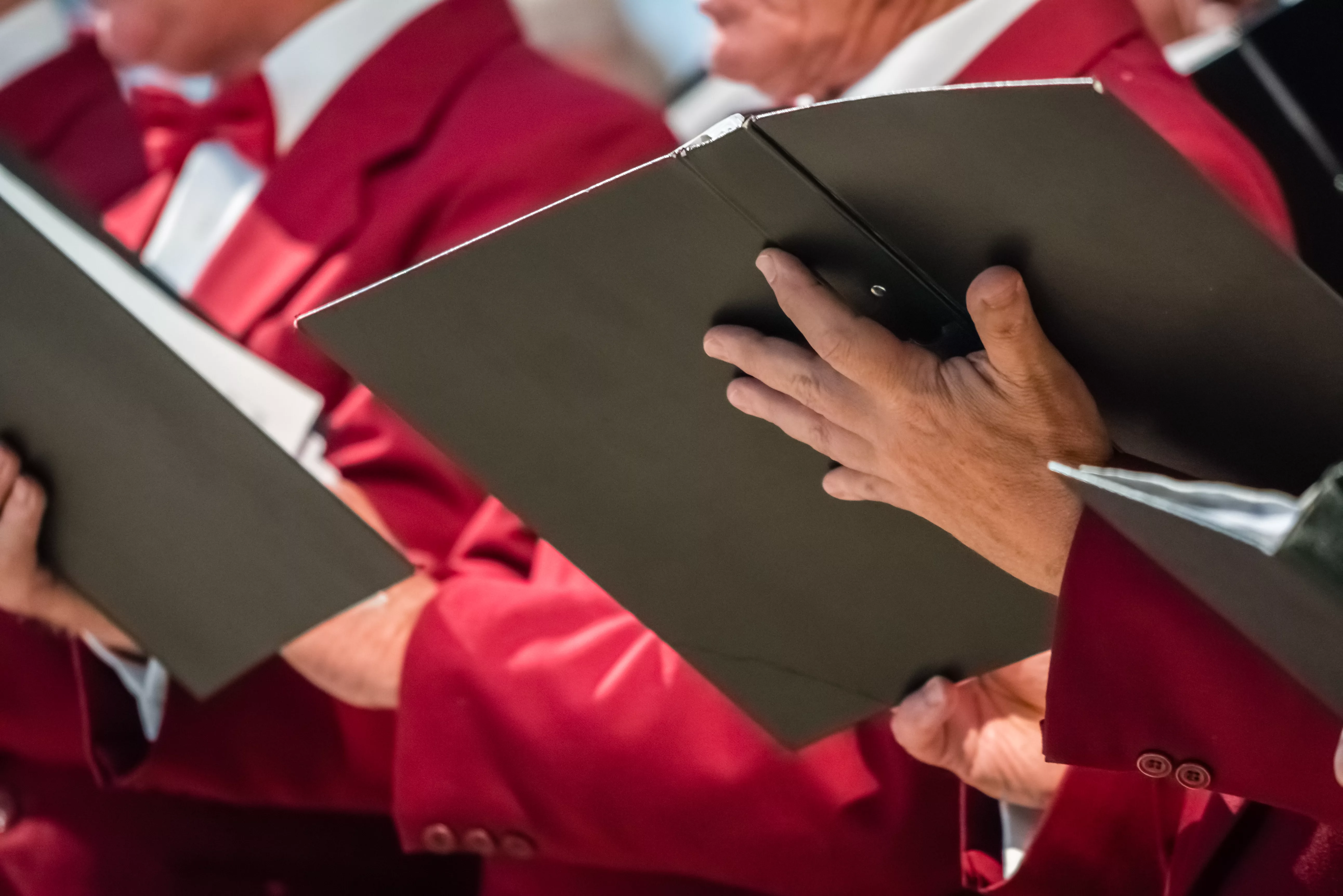 mens-choir-members-holding-singing-book