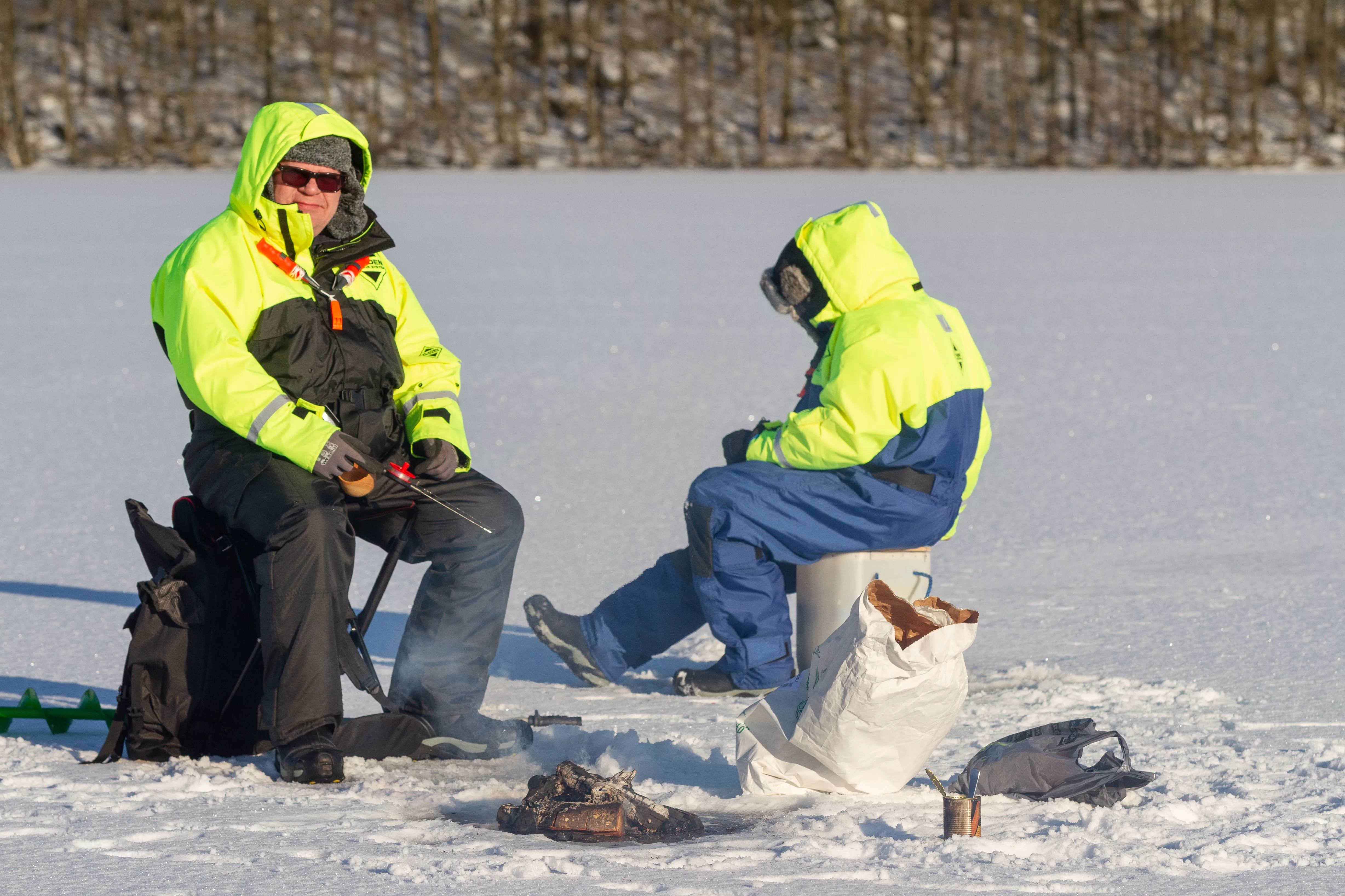 two-men-ice-fishing-on-the-frozen-winter-lake-war-2023-11-27-05-25-37-utc