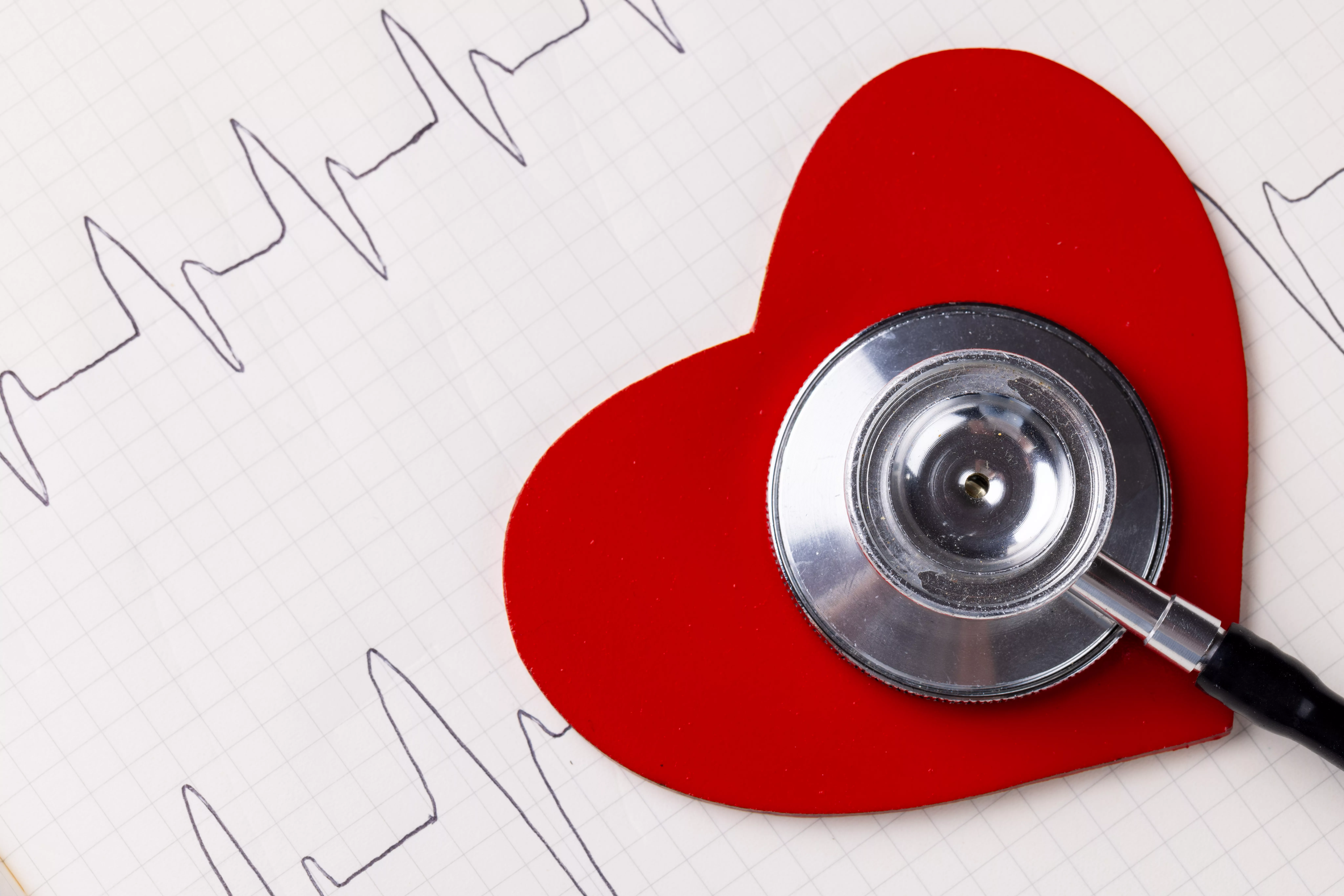 image-of-red-heart-and-stethoscope-on-white-surface-with-heart-rate-health-medicine-prevention-and-heart-illnesses-awareness-concept