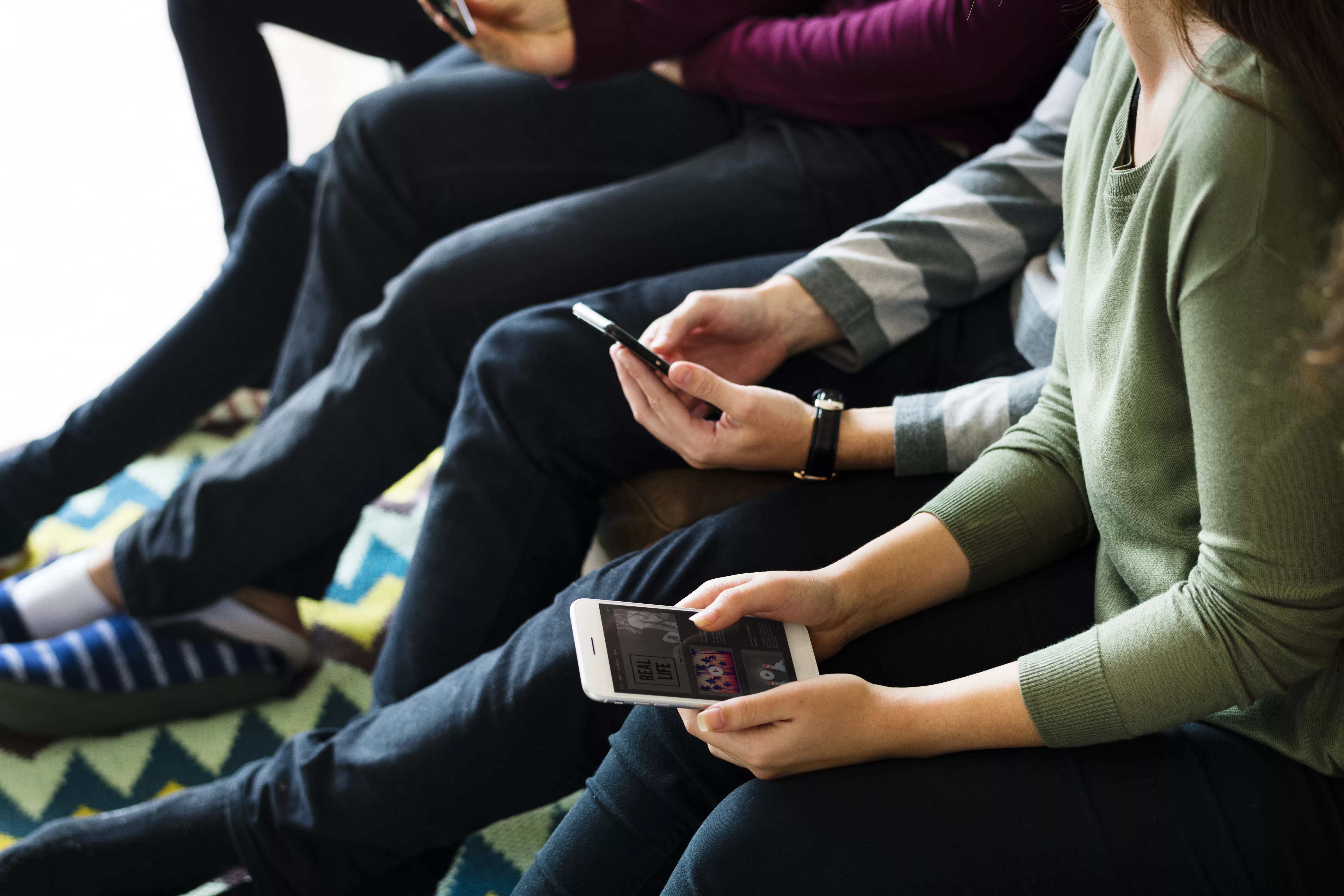group-of-people-using-mobile-phone-on-couch