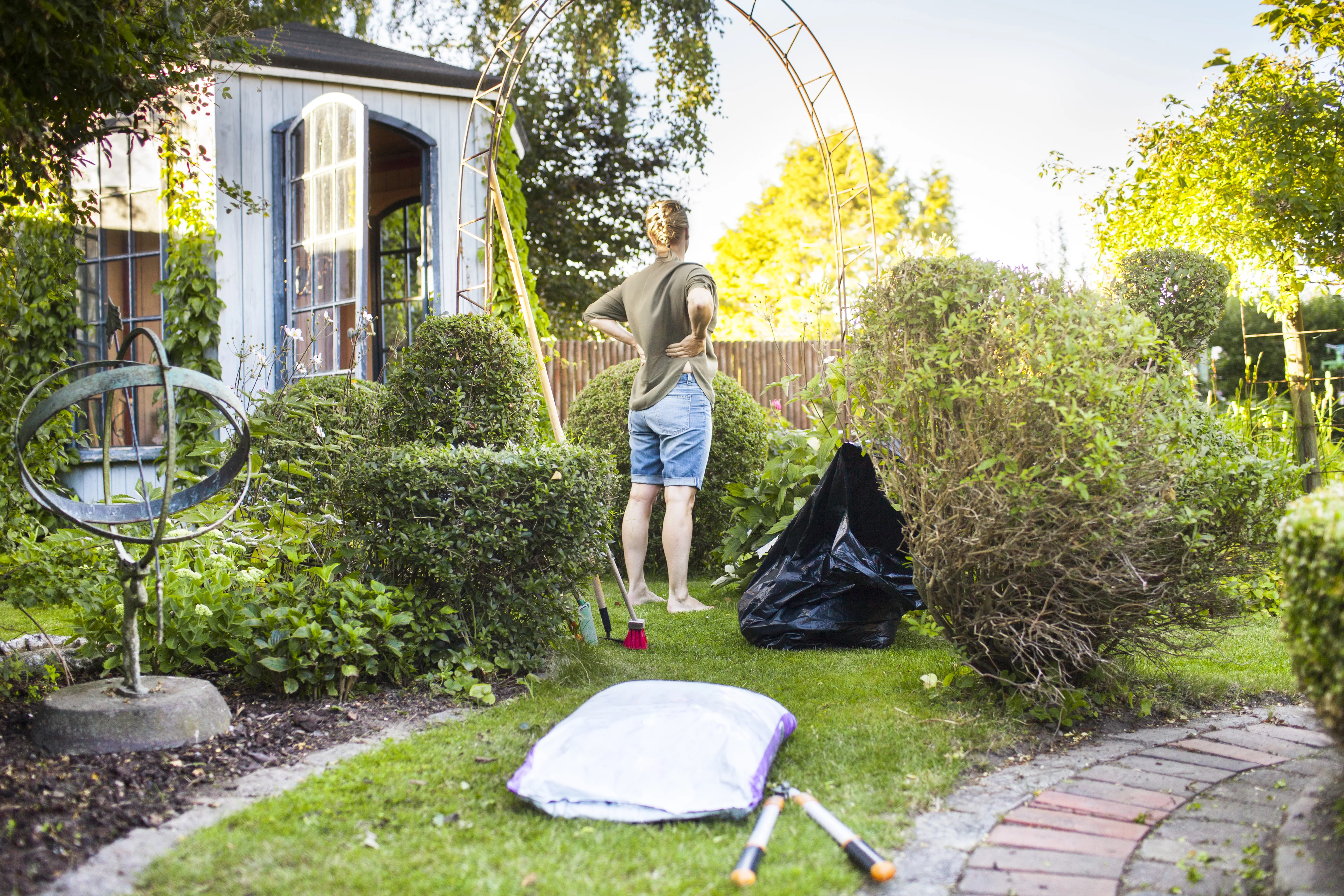 full-length-rear-view-of-woman-gardening-in-backyard