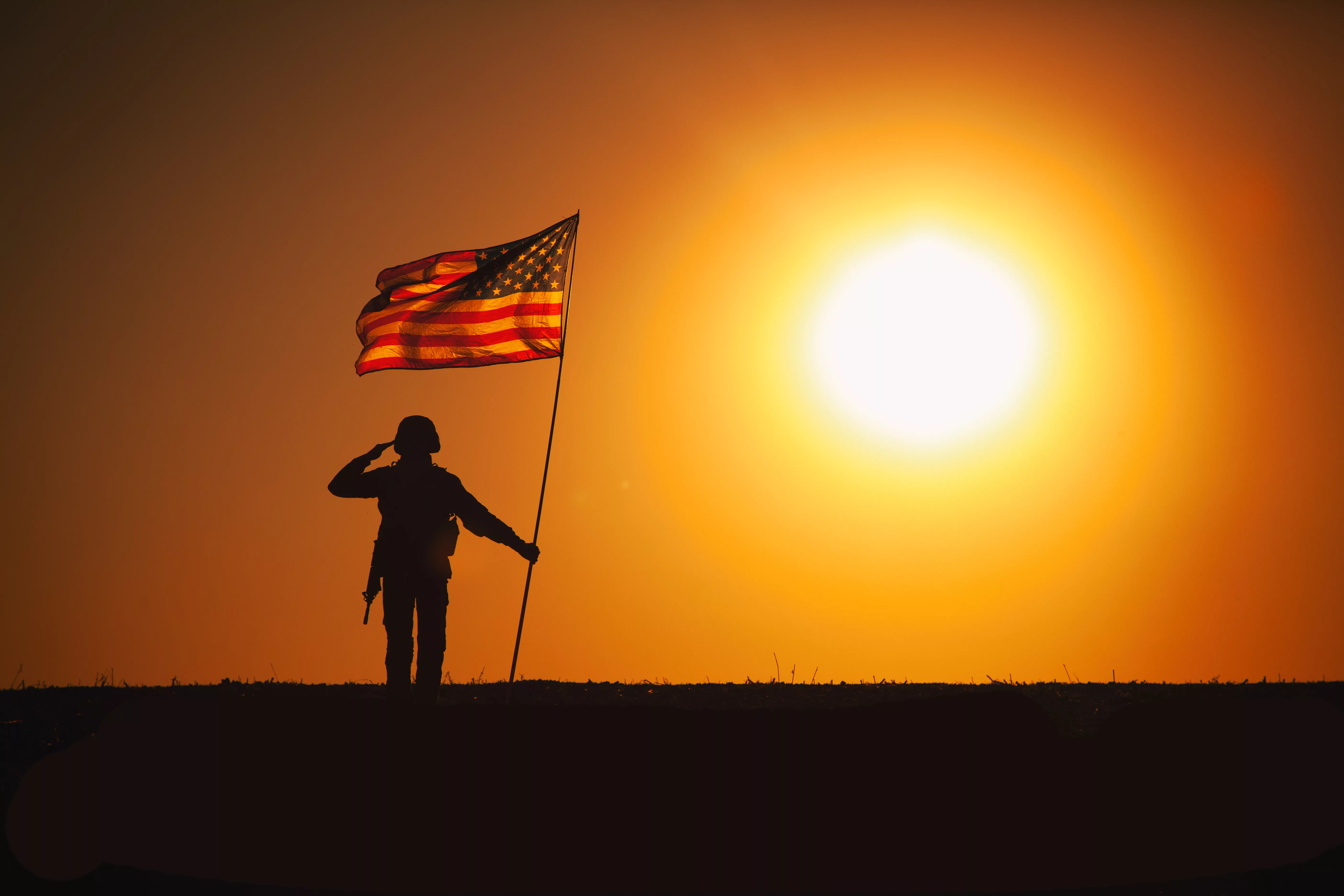 usa-soldier-with-flag-saluting-on-sunset-horizon