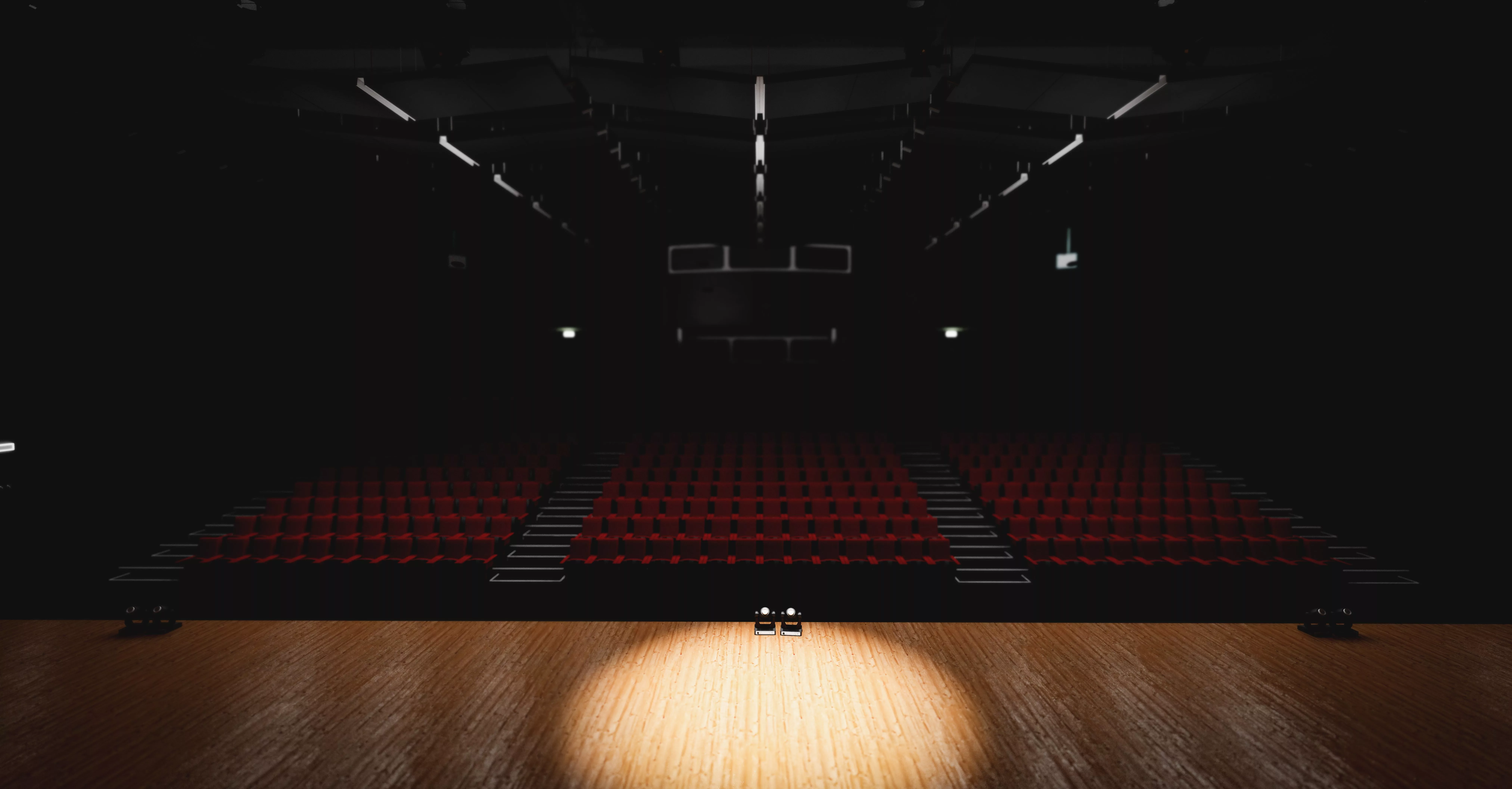 theatre-with-empty-stage-in-spotlight-red-theater-curtain-and-seats