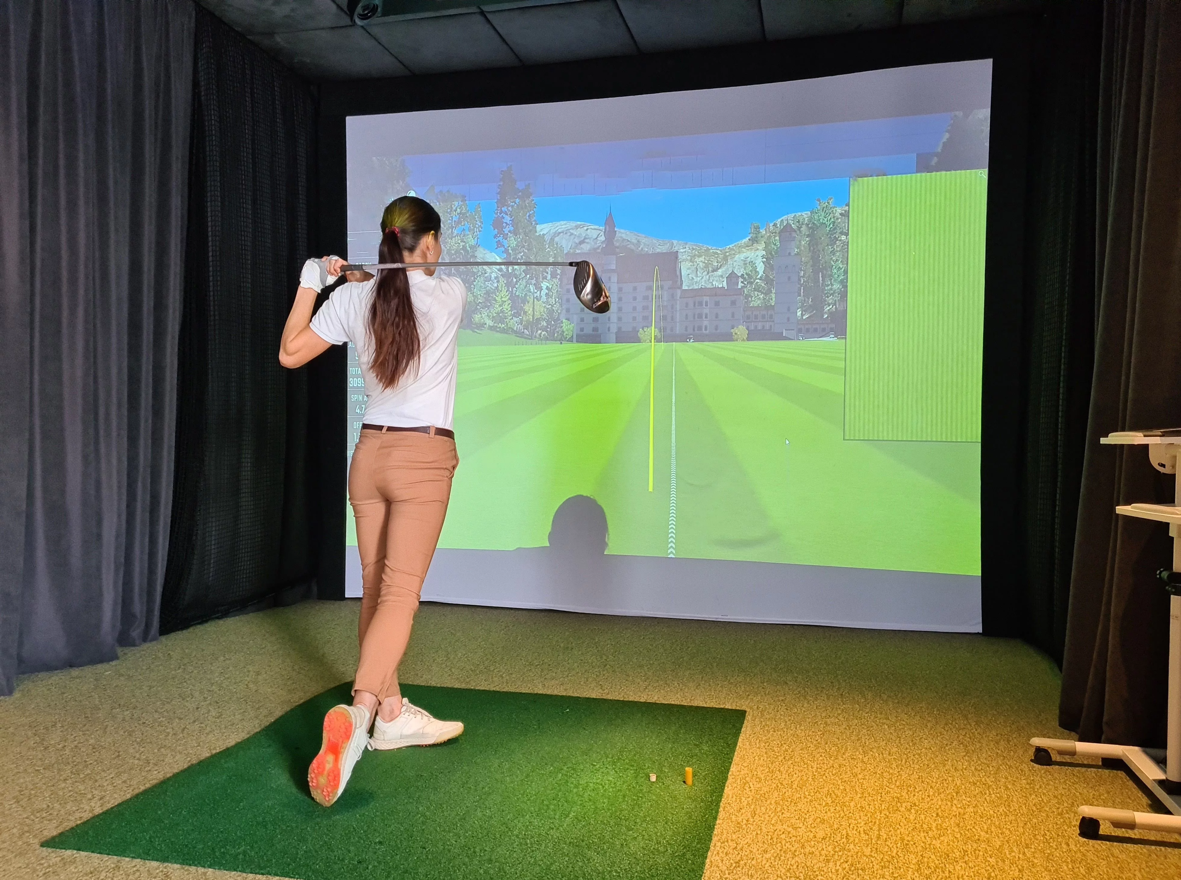 female-golfer-plays-golf-on-golf-simulator